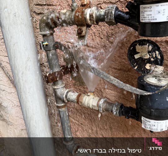 דליפת מים מצינור חלוד על קיר חיצוני
